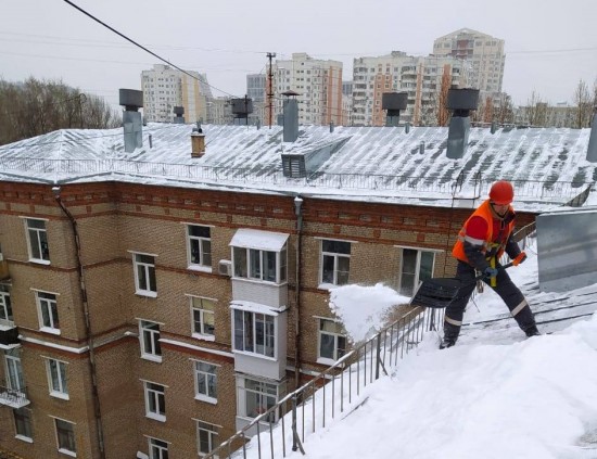 Коммунальщики Академического района убирают снег с кровель домов в постоянном режиме